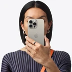 شخص يحمل iPhone&nbsp;15 أمام وجهه لإخفاء هويته