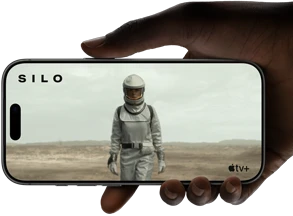 يد تحمل iPhone&nbsp;17&nbsp;Pro،‏ [NDA]، في الوضع الأفقي، فيديو معروض على شاشة تغطي الواجهة بالكامل يوضح عمر البطارية