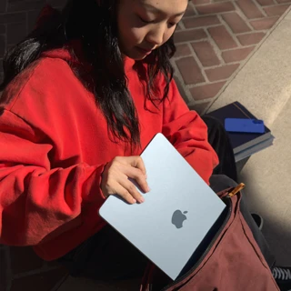 طالبة تضع جهاز MacBook Air مقاس 15 إنش في حقيبة ظهرها