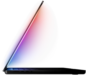 A slightly open MacBook Pro casts a multicolored glow from the screen onto the keyboard