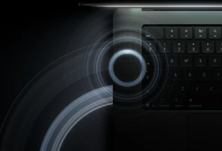 جهاز MacBook Pro مع شاشة PROLED XDR، الغطاء مفتوح، لون أسود فلكي، لوحة المفاتيح مضاءة بضوء الشاشة، دوائر تمثل موجات صوتية تنبعث من الجهة العلوية والجهة اليسرى لهيكل جهاز اللابتوب