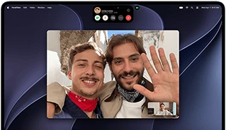 جهاز MacBook Pro مع شاشة PROLED XDR، لون فضي، الشاشة تعرض مكالمة فيديو جارية يظهر فيها شخصان في بلدة مشمسة يلوّحان باليد لشخص في المنزل