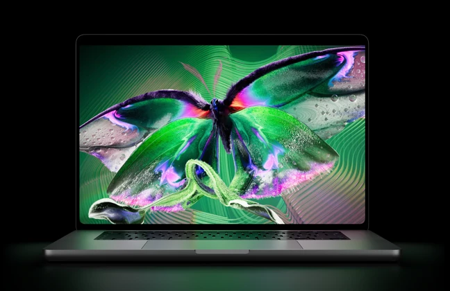 جهاز MacBook Pro مع شاشة PROLED XDR‏، الغطاء مفتوح، لون فضي، الشاشة تعرض صورة غنية بالتفاصيل وعالية التباين مع ألوان زاهية، الشاشة تضيء لوحة المفاتيح