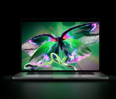جهاز MacBook Pro مع شاشة PROLED XDR‏، الغطاء مفتوح، لون فضي، الشاشة تعرض صورة غنية بالتفاصيل وعالية التباين مع ألوان زاهية، الشاشة تضيء لوحة المفاتيح