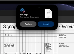 Display shows Dynamic Island with an AirDrop request in a small window over an open Adobe Acrobat file