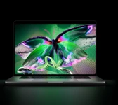 MacBook Pro with PROLED XDR Display, open lid, silver color, display shows detailed, high-contrast image with vivid colors, screen illuminates keyboard
